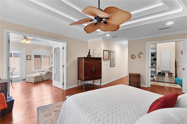 bedroom with visible vents, wood finished floors, and ornamental molding