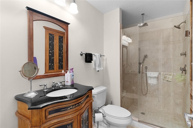 bathroom featuring vanity, toilet, and a stall shower