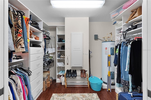 walk in closet featuring water heater and dark wood-style flooring