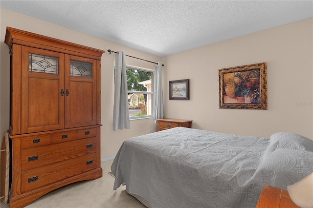 bedroom with light tile patterned flooring and a textured ceiling