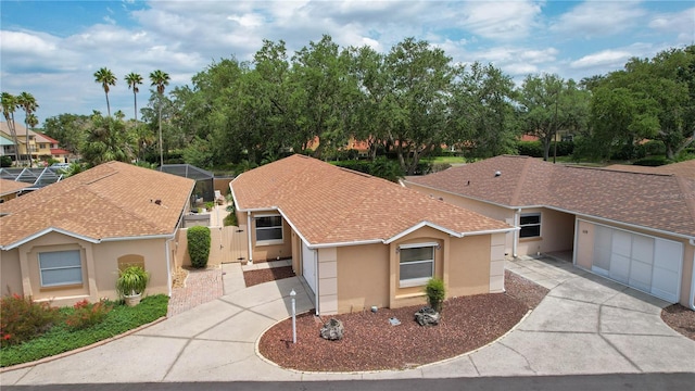 view of front of property with concrete driveway, stucco siding, a gate, and an attached garage