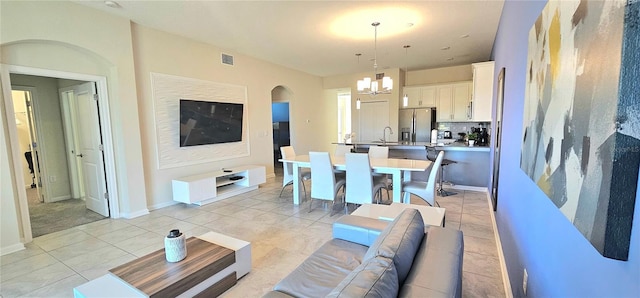 817 Ocean Course Ave Unit 502, Davenport, FL 33896 - living area featuring a chandelier, light tile patterned floors, arched walkways, and baseboards