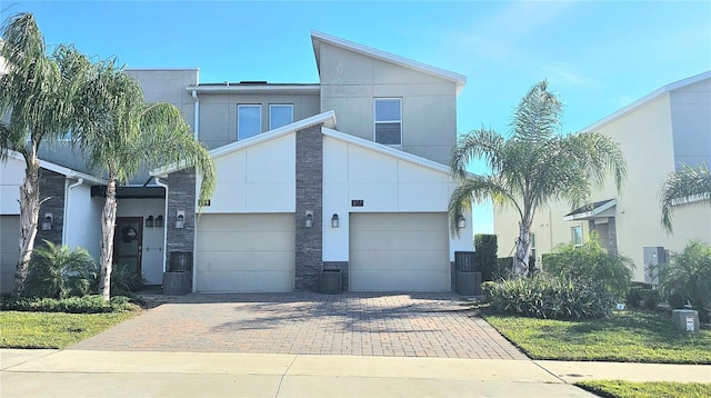 817 Ocean Course Ave Unit 502, Davenport, FL 33896 - view of front of property with stone siding, decorative driveway, an attached garage, and stucco siding
