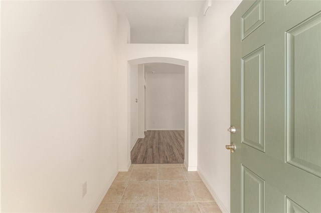 9181 SE 166th Sprung Ln, The Villages, FL 32162 - hallway with light tile patterned floors, baseboards, and arched walkways