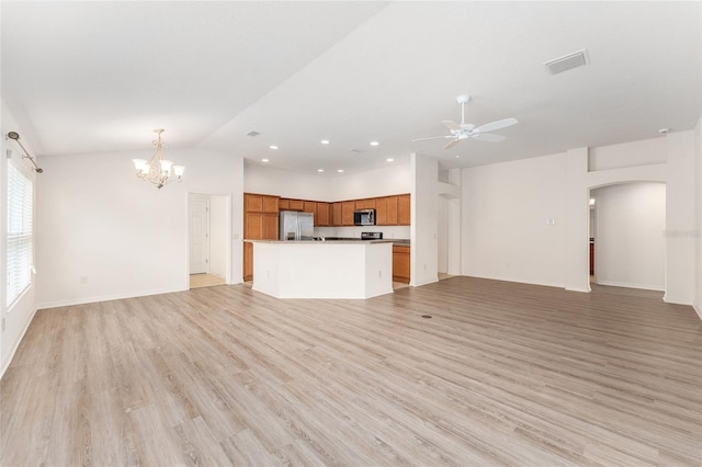 9181 SE 166th Sprung Ln, The Villages, FL 32162 - unfurnished living room with ceiling fan with notable chandelier, visible vents, arched walkways, light wood-style floors, and lofted ceiling