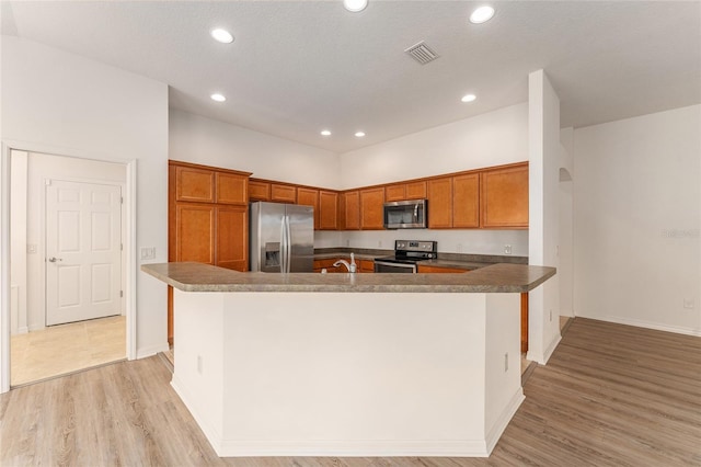 9181 SE 166th Sprung Ln, The Villages, FL 32162 - kitchen with a sink, brown cabinetry, visible vents, appliances with stainless steel finishes, and recessed lighting