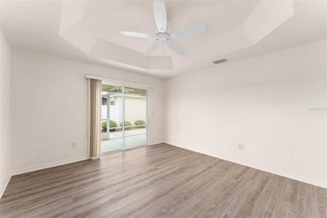 9181 SE 166th Sprung Ln, The Villages, FL 32162 - unfurnished room with ceiling fan, a tray ceiling, visible vents, and wood finished floors