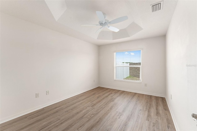 9181 SE 166th Sprung Ln, The Villages, FL 32162 - empty room featuring a tray ceiling, baseboards, ceiling fan, visible vents, and light wood-style floors