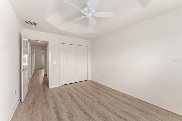 9181 SE 166th Sprung Ln, The Villages, FL 32162 - unfurnished bedroom with light wood-type flooring, visible vents, baseboards, and a raised ceiling