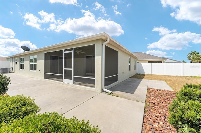 9181 SE 166th Sprung Ln, The Villages, FL 32162 - back of house with a sunroom, stucco siding, fence, and a patio