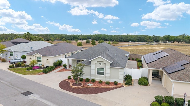 9181 SE 166th Sprung Ln, The Villages, FL 32162 - view of front of property featuring a residential view, stucco siding, fence, concrete driveway, and a shingled roof