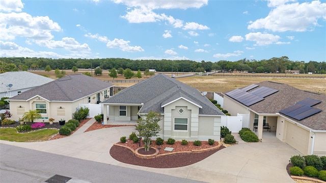 9181 SE 166th Sprung Ln, The Villages, FL 32162 - ranch-style home with stucco siding, roof with shingles, fence, and curved driveway