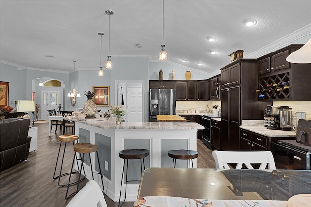 3433 Nestlebranch Ave, The Villages, FL 32163 - kitchen featuring appliances with stainless steel finishes, backsplash, dark wood-style floors, and dark brown cabinets