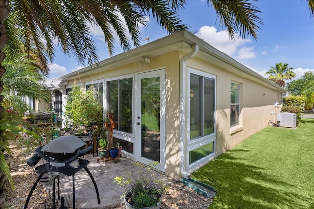 3433 Nestlebranch Ave, The Villages, FL 32163 - view of side of property featuring a lawn, a patio, cooling unit, and stucco siding