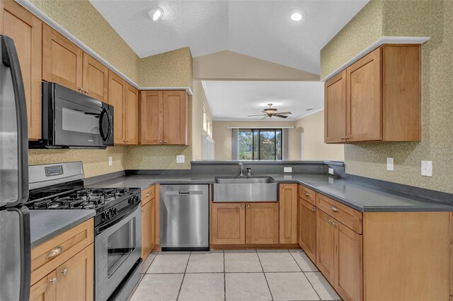 8167 Bridgeport Bay Cir, Mount Dora, FL 32757 - kitchen featuring stainless steel appliances, a sink, vaulted ceiling, dark countertops, and a ceiling fan