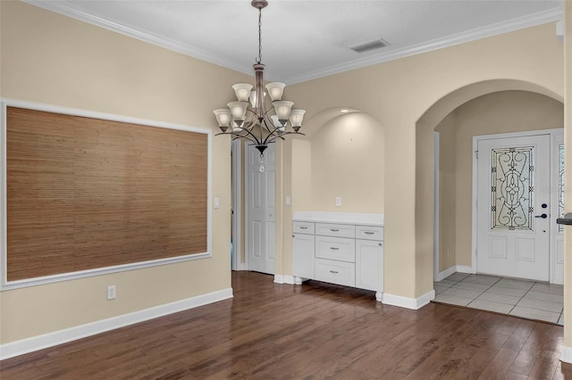 8167 Bridgeport Bay Cir, Mount Dora, FL 32757 - unfurnished dining area featuring arched walkways, dark wood-style floors, a chandelier, ornamental molding, and baseboards