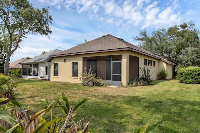 8167 Bridgeport Bay Cir, Mount Dora, FL 32757 - rear view of house featuring a sunroom, stucco siding, a lawn, and roof with shingles