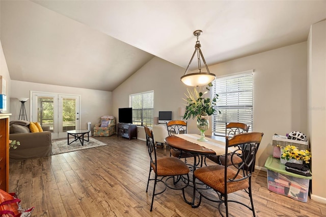 dining room with light wood finished floors, lofted ceiling, and a healthy amount of sunlight