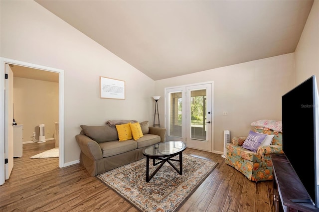living area featuring baseboards, light wood-style flooring, and vaulted ceiling
