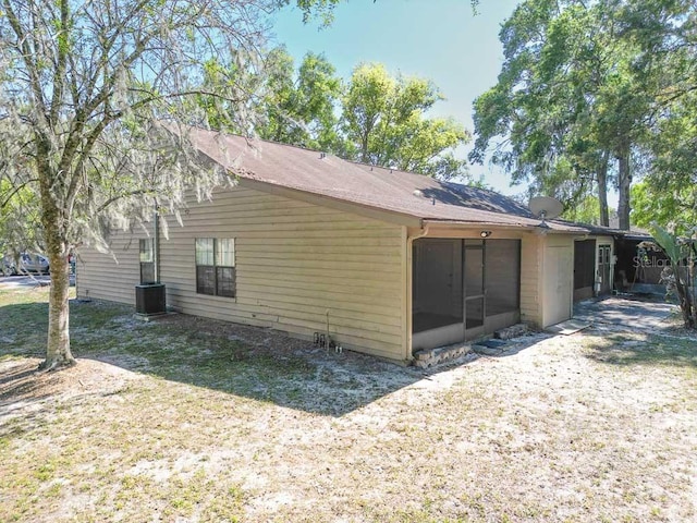 view of side of property featuring a sunroom and central AC unit