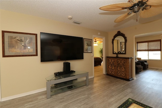 1482 Azteca Loop, The Villages, FL 32162 - living room with light wood-type flooring, a textured ceiling, baseboards, and a ceiling fan