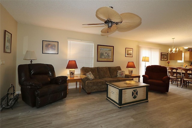 1482 Azteca Loop, The Villages, FL 32162 - living room featuring a textured ceiling, wood finished floors, and ceiling fan with notable chandelier