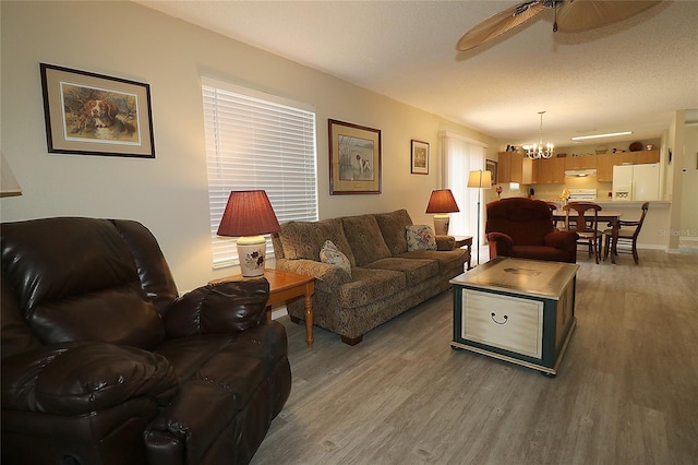 1482 Azteca Loop, The Villages, FL 32162 - living room with ceiling fan with notable chandelier, baseboards, and wood finished floors