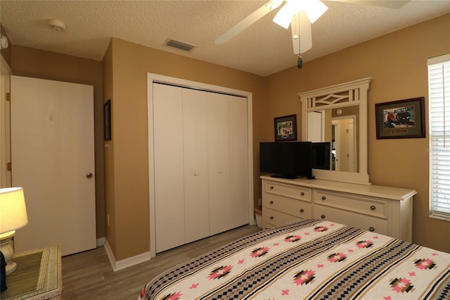 1482 Azteca Loop, The Villages, FL 32162 - bedroom with a closet, light wood-type flooring, visible vents, baseboards, and ceiling fan