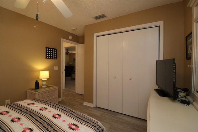 1482 Azteca Loop, The Villages, FL 32162 - bedroom with wood finished floors, a ceiling fan, a closet, a textured ceiling, and visible vents