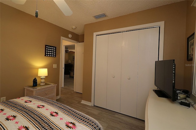 1482 Azteca Loop, The Villages, FL 32162 - bedroom featuring a closet, wood finished floors, a textured ceiling, visible vents, and ceiling fan