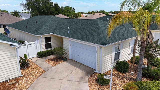 1482 Azteca Loop, The Villages, FL 32162 - view of front of property featuring concrete driveway, roof with shingles, fence, and a garage