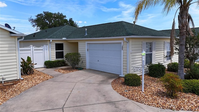 1482 Azteca Loop, The Villages, FL 32162 - ranch-style house featuring driveway, a shingled roof, an attached garage, and fence
