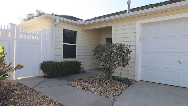 1482 Azteca Loop, The Villages, FL 32162 - view of exterior entry with roof with shingles, fence, and a garage