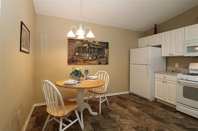 1070 Pinewood Pl, The Villages, FL 32162 - kitchen featuring white appliances, stone finish flooring, a chandelier, baseboards, and white cabinetry