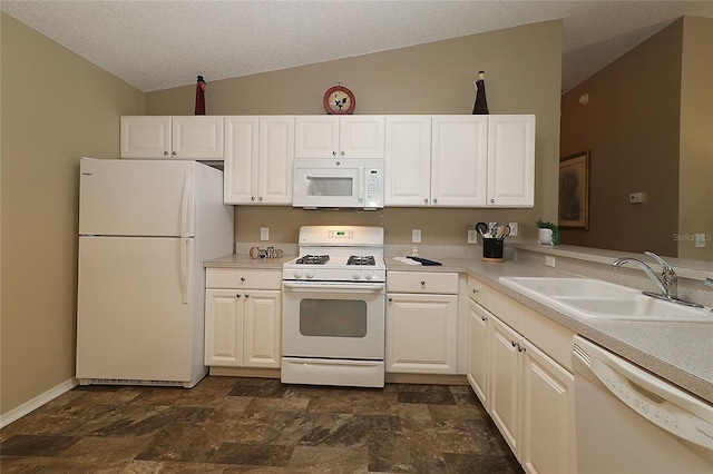 1070 Pinewood Pl, The Villages, FL 32162 - kitchen featuring white appliances, a sink, vaulted ceiling, stone finish flooring, and light countertops