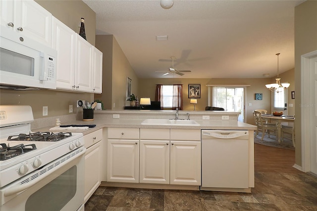 1070 Pinewood Pl, The Villages, FL 32162 - kitchen featuring white appliances, a sink, a peninsula, a chandelier, and white cabinets