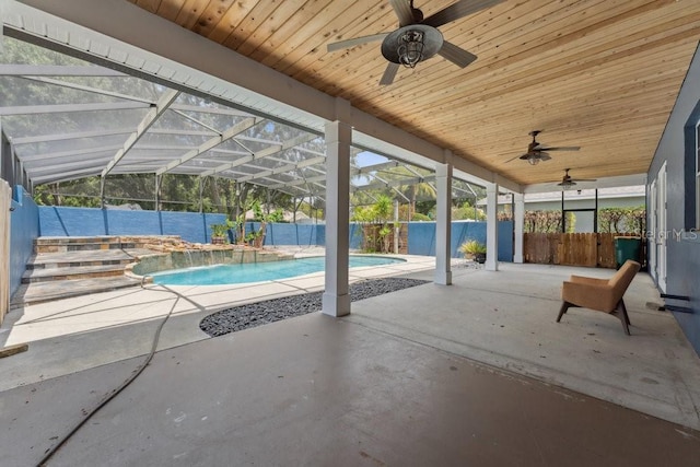 view of swimming pool with ceiling fan, a patio, a fenced backyard, a fenced in pool, and glass enclosure
