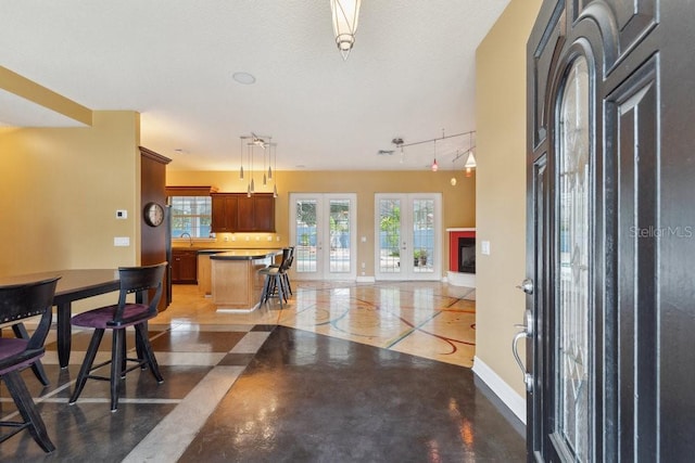 entryway featuring baseboards and rail lighting