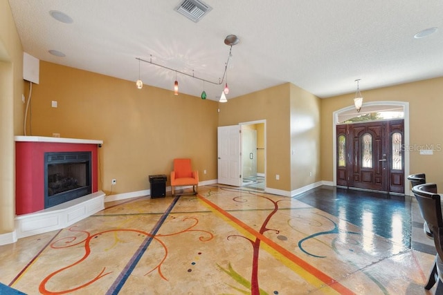 entrance foyer with a fireplace with raised hearth, baseboards, and visible vents