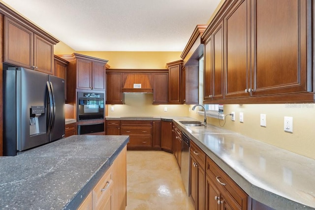 kitchen featuring a sink, a warming drawer, brown cabinetry, and stainless steel appliances