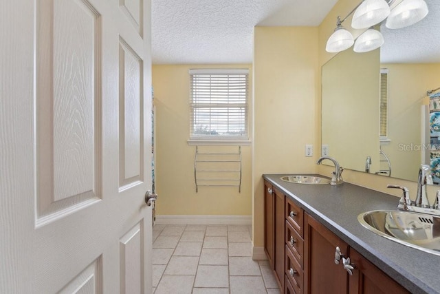 bathroom with double vanity, a sink, and a textured ceiling