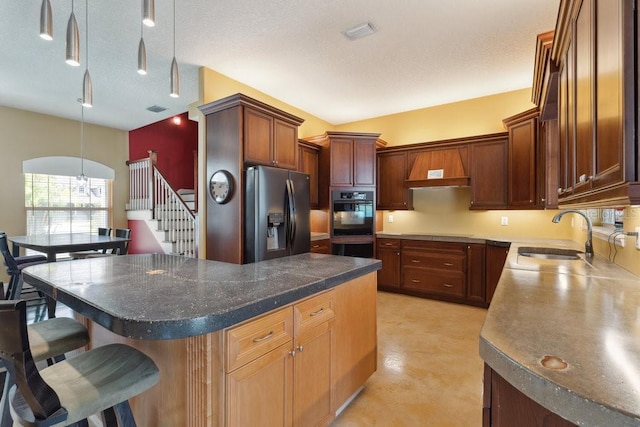 kitchen with a kitchen breakfast bar, decorative light fixtures, a sink, black appliances, and custom range hood