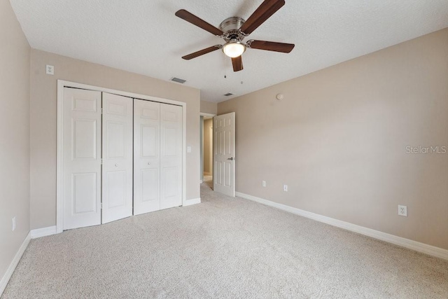unfurnished bedroom with light colored carpet, baseboards, visible vents, and a closet