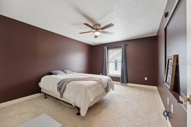 bedroom with a ceiling fan, baseboards, carpet, and a textured ceiling