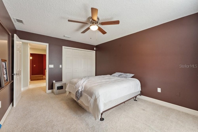 bedroom with baseboards, a closet, light colored carpet, and visible vents