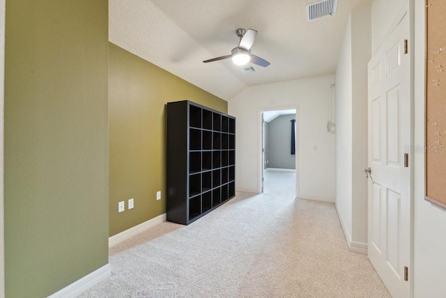 interior space with a ceiling fan, baseboards, visible vents, and lofted ceiling