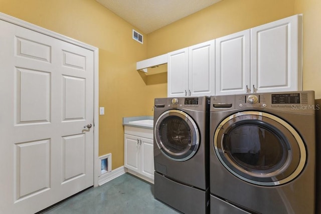 laundry area featuring cabinet space, visible vents, and washer and dryer