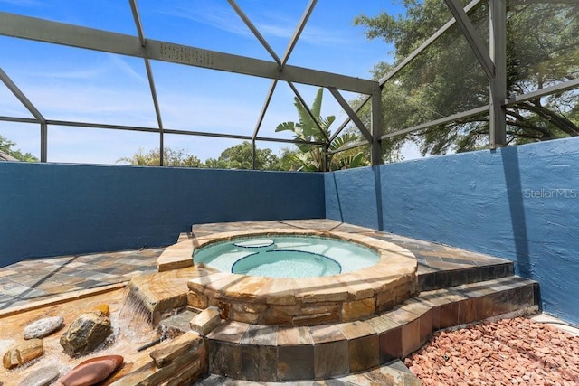 view of swimming pool featuring a lanai and an in ground hot tub