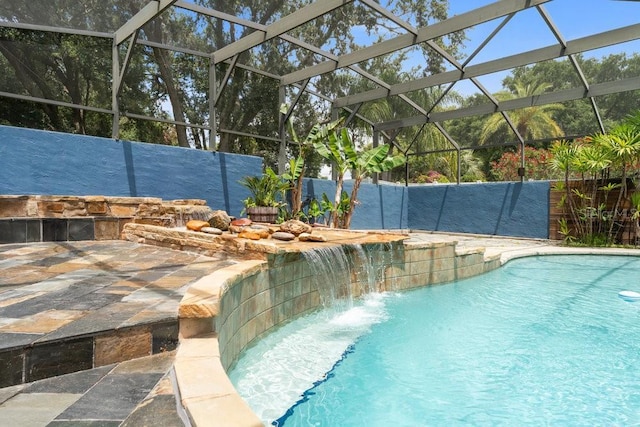 view of swimming pool with glass enclosure, a fenced in pool, and a patio area
