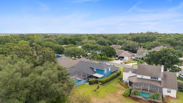 drone / aerial view featuring a residential view and a view of trees